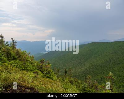 Ein atemberaubender Blick vom Gipfel des Cascade Mountain, wo Lichtstrahlen durch schwere Wolken dringen und die Adirondacks im Bundesstaat New York erleuchten. Stockfoto