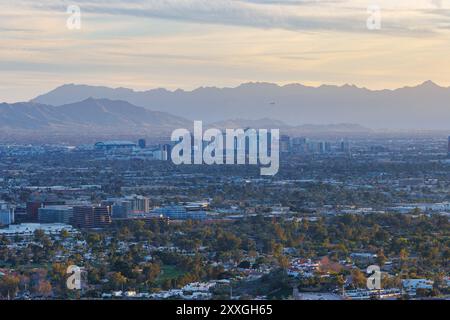 Majestätischer Sonnenuntergang über Phoenix: Ein atemberaubender Blick aus der Luft auf Arizonas geschäftige Metropole vor dem Hintergrund der Desert Mountains und eines ruhigen Himmels. Stockfoto