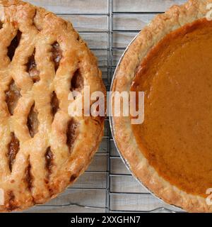 Nahaufnahme der Feiertags-Apfel- und Kürbiskuchen auf Kühlregalen. Nur die Hälfte jedes Kreisdiagramms wird angezeigt. Quadratisches Format. Stockfoto