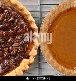 Nahaufnahme der Feiertage Pecan und Kürbis Pies auf Kühlregalen. Nur die Hälfte jedes Kreisdiagramms wird angezeigt. Quadratisches Format. Stockfoto