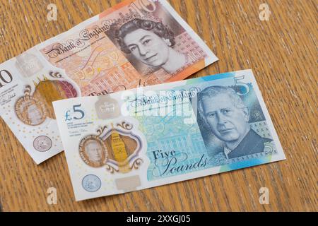 Alte und neue britische Polymer-Banknoten - eine 10-Pfund-Banknote mit Queen Elizabeth Kopf und eine 5-Pfund-Banknote mit King Charles Kopf Stockfoto