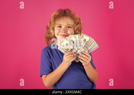 Geld gewinnt, viel Glück. Der Junge hat viele hundert Dollar isoliert im Studiohintergrund. Stockfoto