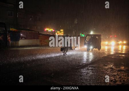 Dhaka, Dhaka, Bangladesch. August 2024. Menschen überqueren die Straße bei sintflutartigen Regenfällen am 25. August 2024 in Dhaka, Bangladesch. Infolge der anhaltenden Starkregenfälle kommt es in vielen Gegenden einschließlich Feni und Comilla Khagrachari in Bangladesch zu Überschwemmungen und haben seit Beginn der Woche mindestens 42 Menschen in Bangladesch und Indien getötet, viele davon durch Erdrutsche. (Kreditbild: © Abu Sufian Jewel/ZUMA Press Wire) NUR REDAKTIONELLE VERWENDUNG! Nicht für kommerzielle ZWECKE! Quelle: ZUMA Press, Inc./Alamy Live News Stockfoto