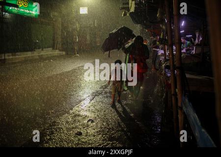 Dhaka, Dhaka, Bangladesch. August 2024. Menschen überqueren die Straße bei sintflutartigen Regenfällen am 25. August 2024 in Dhaka, Bangladesch. Infolge der anhaltenden Starkregenfälle kommt es in vielen Gegenden einschließlich Feni und Comilla Khagrachari in Bangladesch zu Überschwemmungen und haben seit Beginn der Woche mindestens 42 Menschen in Bangladesch und Indien getötet, viele davon durch Erdrutsche. (Kreditbild: © Abu Sufian Jewel/ZUMA Press Wire) NUR REDAKTIONELLE VERWENDUNG! Nicht für kommerzielle ZWECKE! Quelle: ZUMA Press, Inc./Alamy Live News Stockfoto