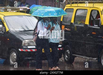 Mumbai, Indien. August 2024. MUMBAI, INDIEN - 24. AUGUST: Menschen durchqueren den starken Regen auf der Straße während des Monsunregens in der Gegend von Byculla am 24. August 2024 in Mumbai, Indien. (Foto: Bhushan Koyande/Hindustan Times/SIPA USA) Credit: SIPA USA/Alamy Live News Stockfoto