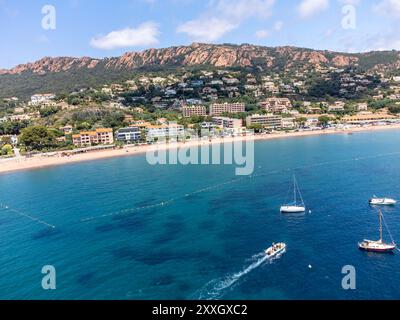 Panoramablick von oben auf das blaue Mittelmeer dea, Sandstrand der Stadt Agay, Sommerferienziel in der Nähe der roten Berge von Esterel, französische Riviera, Stockfoto