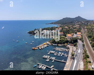 Panoramablick von oben auf das blaue Mittelmeer dea, Sandstrand der Stadt Agay, Sommerferienziel in der Nähe der roten Berge von Esterel, französische Riviera, Stockfoto