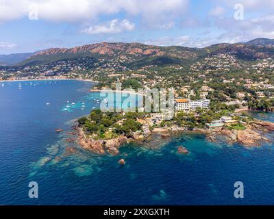 Panoramablick von oben auf das blaue Mittelmeer dea, Sandstrand der Stadt Agay, Sommerferienziel in der Nähe der roten Berge von Esterel, französische Riviera, Stockfoto