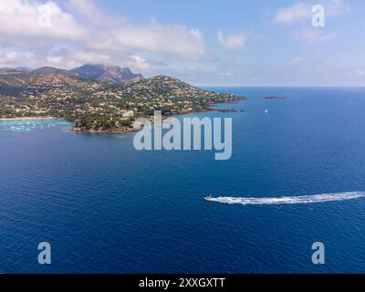 Panoramablick von oben auf das blaue Mittelmeer dea, Sandstrand der Stadt Agay, Sommerferienziel in der Nähe der roten Berge von Esterel, französische Riviera, Stockfoto