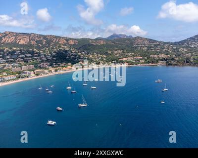 Panoramablick von oben auf das blaue Mittelmeer dea, Sandstrand der Stadt Agay, Sommerferienziel in der Nähe der roten Berge von Esterel, französische Riviera, Stockfoto