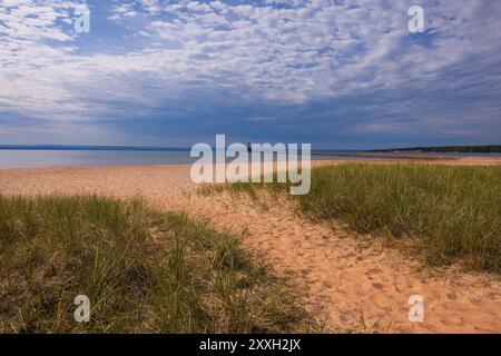 Ein leerer Sandstrand mit einem Leuchtturm am Lake Superior. Stockfoto