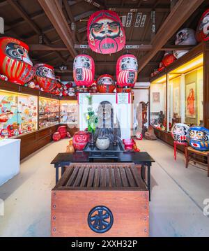 gunma, takasaki - 25. januar 2024: Eine Sammlung, die die Geschichte der japanischen buddhistischen roten Daruma-Puppen mit weißen Gesichtern, die die Beharrlichkeit repräsentieren, nachzeichnet Stockfoto