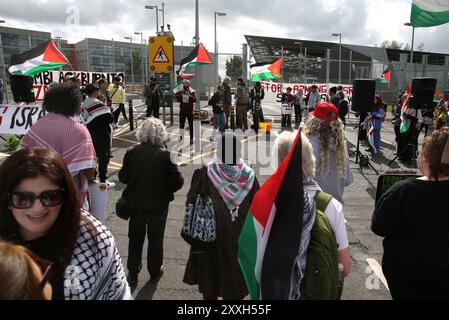 Blackburn, England, Großbritannien. August 2024. Die Demonstranten hören während der Demonstration vor den Haupttoren der BAE Systems-Anlage Reden. Demonstranten beschuldigen BAE Systems, am Völkermord in Gaza beteiligt zu sein, indem sie Teile für die F-35-Kampfflugzeuge in ihrer Anlage in Samlesbury herstellen, die beim Luftangriff auf Gaza und den Jemen eingesetzt wurden. Seit dem 10/24 wurden über 5000 Luftangriffe auf Gaza gerichtet, bei denen Tausende von Zivilisten getötet wurden, darunter 16.500 Kinder. Quelle: ZUMA Press, Inc./Alamy Live News Stockfoto