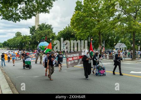 Washington DC, USA - 19.08.2024: Eine Gruppe von Menschen marschiert mit einem Banner die Straße hinunter, auf dem steht: "Auch die palästinensischen Menschenrechte sind wichtig" Stockfoto