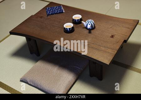 Japanische Tee Tisch, Chabudai mit einer Teekanne und zwei Tassen, Zabuton sitzen Kissen auf Tatami Matten mit einer traditionellen japanischen Zimmer in einem Ryokan Inn in Kyot Stockfoto