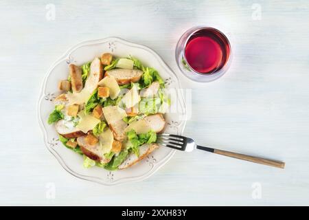 Hühnchen Caesar Salat, Schuß von der Oberseite mit einem Glas Wein und einem Platz für Text Stockfoto