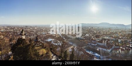 Österreich, 20.01.2019: Weites Panorama der Stadt Graz, Stadtdächer, Mur und Stadtzentrum, Schlossberg und Uhrturm Sonne im Winter, blauer Himmel. T Stockfoto