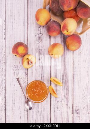 Pfirsichmarmelade auf einem alten Holztisch als detaillierte Nahaufnahme, selektiver Fokus Stockfoto