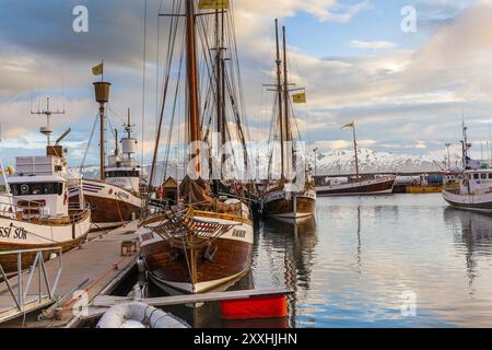 HUSAVIK, ISLAND, 29. JUNI: Am 29. JUNI 2013 ankerten Walbeobachtungsschoner bei Sonnenaufgang im Hafen von Husavik und den Bergen im Hintergrund in Husavik Stockfoto