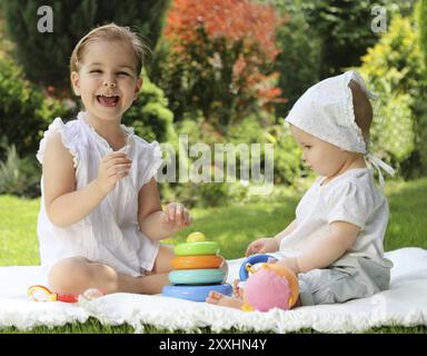 Zwei spielende kleine Schwestern im Sommergarten Stockfoto