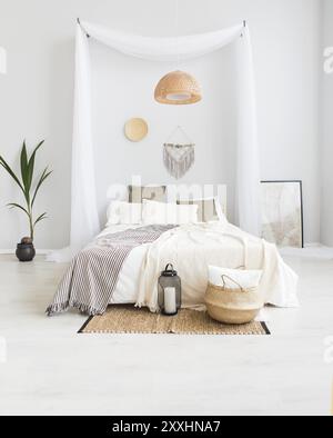 Weiß und Beige Schlafzimmer in boho Style mit macrame an der Wand Stockfoto