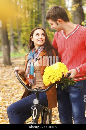 Glückliches junges Paar, mit dem Fahrrad im Herbst park Stockfoto