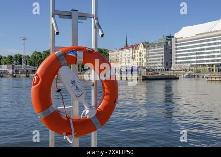 Rettungsschwimmer auf einem Geländer am Hafen, Gebäude und ein klarer blauer Himmel im Hintergrund, Helsinki, Finnland, Europa Stockfoto