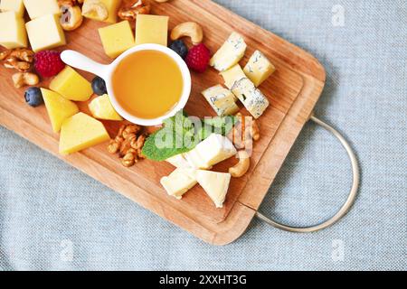 Käse, Honig, Beeren und Nüsse auf Holz board Stockfoto