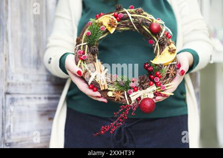 Weihnachten handgefertigte Kranz in jungen womans Hände. Winterurlaub feier Konzept Stockfoto