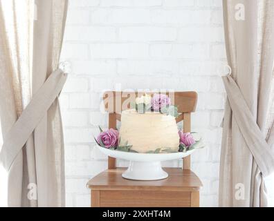 Hochzeitstorte mit rosa Blumen auf Kuchen stand Stockfoto