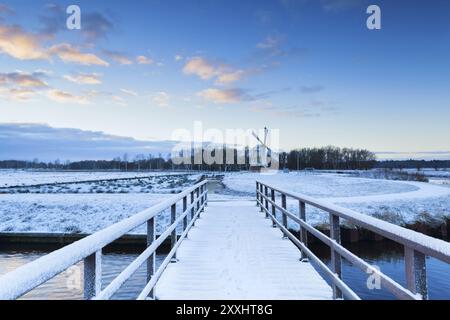 Brücke zur Windmühle im verschneiten Winter, Niederlande Stockfoto