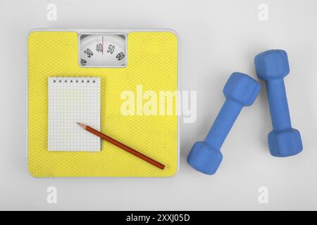 Eine Waage, ein Notizbuch mit Bleistift und eine Kurzhantel. Sportkonzept Stockfoto