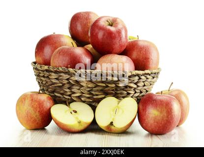 Komposition mit Äpfeln und Weidenkorb isoliert auf weiss Stockfoto