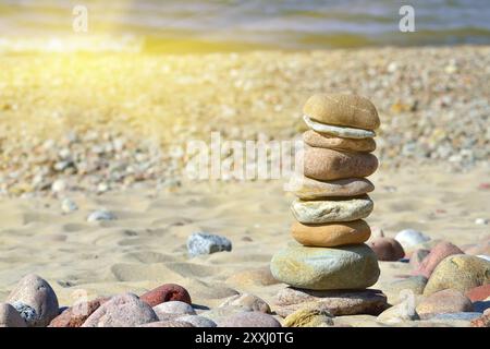 Pyramide aus farbigen Kieselsteinen an einem sonnigen Strand Stockfoto