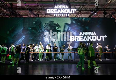 Köln, Deutschland. August 2024. Die Leute stellen sich an, um den Arena Breakout am Stand der MOREFUN auf der gamescom 2024 in Köln, Deutschland, 22. August 2024 zu probieren. Die fortlaufende gamescom, die sich selbst als das weltweit größte Spieleevent bezeichnet, bietet Spieleentwicklern und -Fans eine einzigartige Gelegenheit, sich zu vernetzen und die neuesten Trends in der Gaming-Branche zu erkunden, wobei die Organisatoren daran interessiert sind, in Zukunft mehr chinesische Partner zu haben. Mit einer Rekordzahl von mehr als 1.400 Ausstellern aus 64 Ländern öffnete die Veranstaltung am Mittwoch die Türen für Besucher. Quelle: Zhang Fan/Xinhua/Alamy Live News Stockfoto