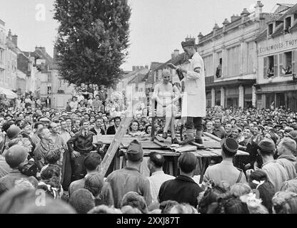 Eine Frau, die mit den Deutschen zusammengearbeitet hat, die in Melun in Frankreich bestraft wurden. Mitglieder des Widerstands rasieren der Frau die Haare, bevor sie durch die Straßen gleiten. Das Foto stammt vom 26. August 1944. Stockfoto