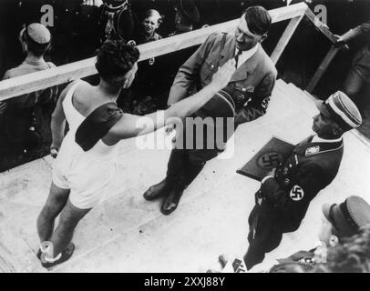 Ein Athlet grüßt Hitler bei einer Zeremonie in Koblenz. Reichssportführer Hans von Tschammer und Osten (rechts) ist dabei, die Loyalitätsbotschaft des Athleten gegenüber Hitler zu präsentieren. Stockfoto