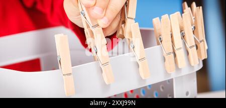 Vorschulkinder spielen mit Holzclip. Entwicklung von motorischen Fähigkeiten, Koordination und Kreativität der Kinder Stockfoto