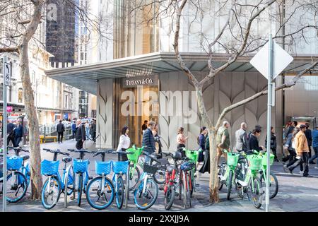 Das Tiffany & Co Juweliergeschäft gewinnt die Sydney King Street, mit elektrischen E-Share-Fahrrädern, die draußen auf dem Bürgersteig gemietet werden können, während die Käufer vorbeigehen, Sydney City Stockfoto