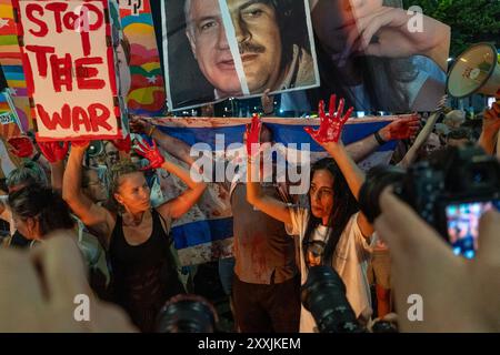 Tel Aviv, Israel. August 2024. Familienmitglieder der israelischen Geiseln mit rot bemalten Händen, die sich auf das Blut an den Händen der israelischen Regierung beziehen, weil sie die Geiseln nicht freilassen konnte, und eine sofortige Geiselnahme fordern. Israelische Demonstranten und Familienangehörige israelischer Geiseln, die während des tödlichen Terroranschlags der Hamas am 7. Oktober nach Gaza entführt wurden, protestieren in Tel Aviv und fordern die israelische Regierung auf, unverzüglich eine Geiselnahme und einen Waffenstillstand zu erreichen. (Foto: Sharon Eilon/SOPA Images/SIPA USA) Credit: SIPA USA/Alamy Live News Stockfoto