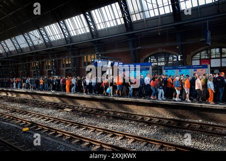 ZANDVOORT - Rennfans am Amsterdamer Hauptbahnhof auf dem Weg nach Zandvoort zum Renntag des Grand Prix der Niederlande. ANP RAMON VAN FLYMEN Stockfoto