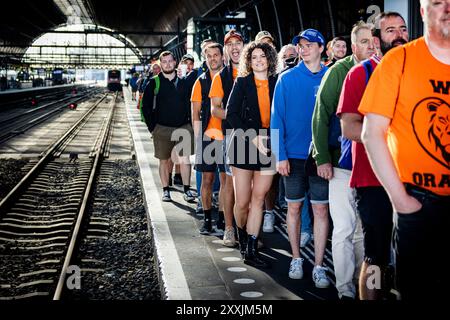 ZANDVOORT - Rennfans am Amsterdamer Hauptbahnhof auf dem Weg nach Zandvoort zum Renntag des Grand Prix der Niederlande. ANP RAMON VAN FLYMEN Stockfoto