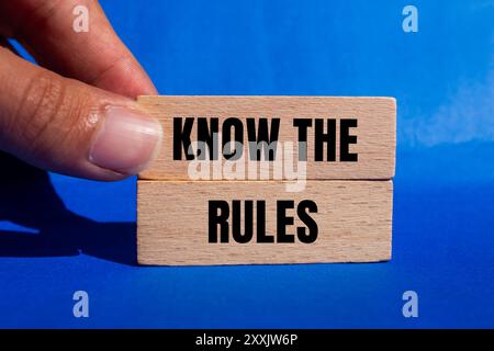 Kennen Sie die Nachricht über die Regeln, die auf Holzblöcken mit blauem Hintergrund geschrieben ist. Das Symbol Regeln kennen. Kopierbereich. Stockfoto