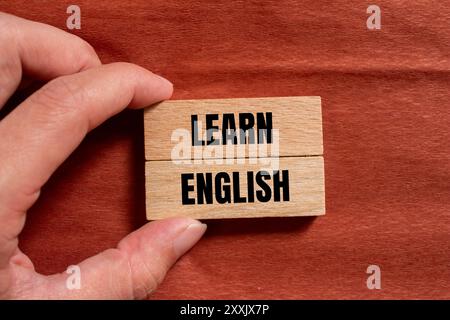 Lernen Sie englisch auf Holzblöcken mit braunem Hintergrund. Symbol für konzeptuelles Lernen englisch. Kopierbereich. Stockfoto