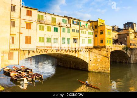 Ruderboot unter der historischen Brücke Ponte Vecchio in Florenz, Italien Stockfoto