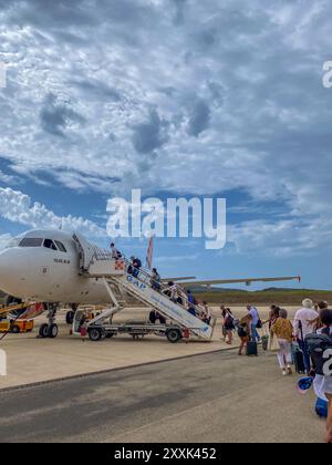 Pantelleria Island, Sizilien, Italien - 03. August 2024: Passagiere steigen in ein Flugzeug der spanischen Billigfluggesellschaft Volotea mit einer Leiter auf dem Pantelleria-Flugzeug Stockfoto