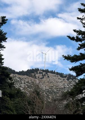 Windenergieanlage auf dem Berg, blauer bewölkter Himmel, erneuerbare grüne Energie Stockfoto