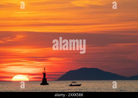 Ein kleines Fischerboot, das vor einer untergehenden Sonne in der Adria in Kroatien liegt. Stockfoto