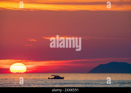 Ein kleines Fischerboot, das vor einer untergehenden Sonne in der Adria in Kroatien liegt. Stockfoto