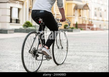 Der perfekte Stadtverkehr. Nahaufnahme eines jungen Mannes, der auf seinem Fahrrad sitzt, während er die Straße entlang fährt Stockfoto